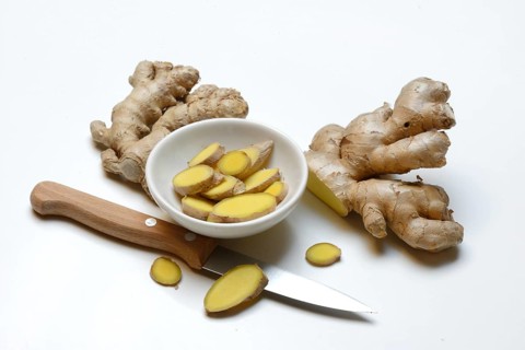 Ginger, ginger tubers and ginger slices in small bowls