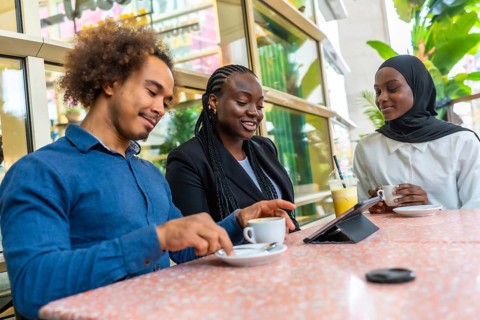 Diverse group of young adult friends enjoying a casual meeting in a modern cafe, sharing