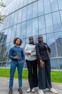 Young diverse business team standing together with confidence outdoors, reflecting professionalism,