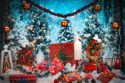 Winter Christmas scene with gifts and candles in front of snowy trees
