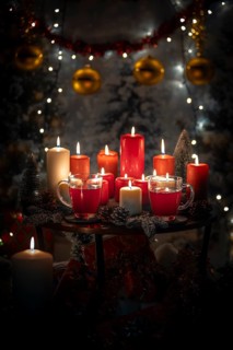 Table with red and white candles and cups, Christmas atmosphere with lights