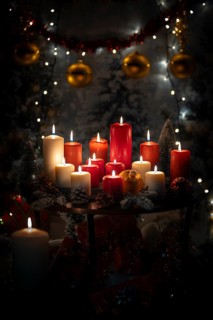 Burning red and white candles on a Christmassy decorated background with balls