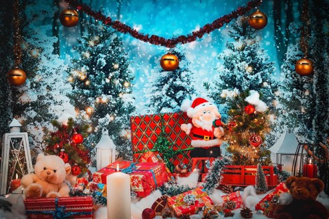 Christmas scene with Santa Claus and stuffed animals surrounded by lights and gifts against a