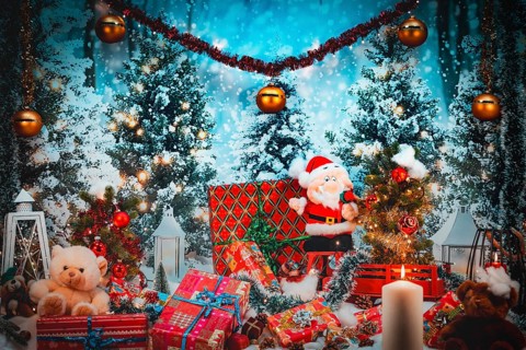 Santa Claus and plush toys in front of snow-covered trees surrounded by festive gifts and candles