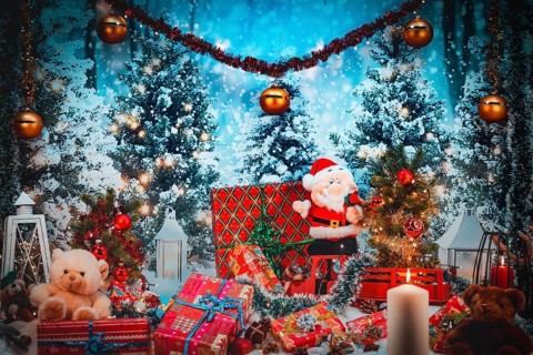 Scene decorated in winter with Santa Claus, candlelight and plenty of gifts under trees