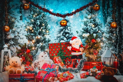 Santa Claus and plush toys surrounded by gifts and lights in snowy winter forest