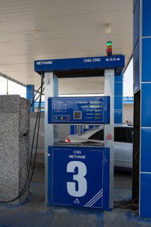 CNG station with blue gas pump, methane display and vehicle in background, gas filling station,