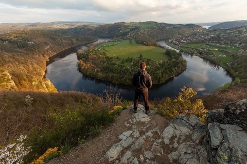 Man standing on a rock at sunset on spring evening at the loop of the Vltava (Vltava) View Solenice