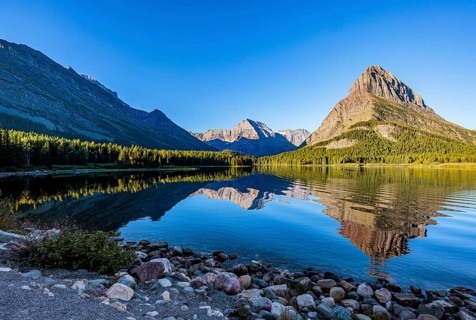 240831_066 Rippled reflection of the mountains on the calm waters of Lake Josephine in Glacier