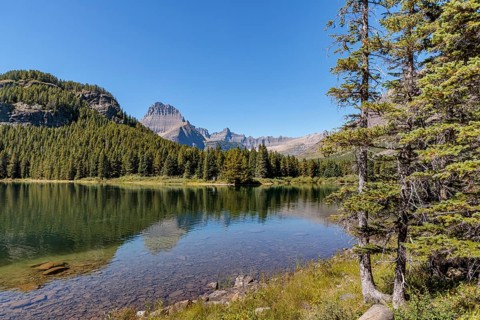 240831_310 Calm clear waters of Swiftcurrent Lake in Glacier National Park, Montana, USA