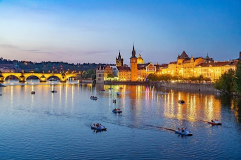 Vltava embankment with Old Town Water Tower, Novotný Bridge and Charles Bridge at dusk, Prague,