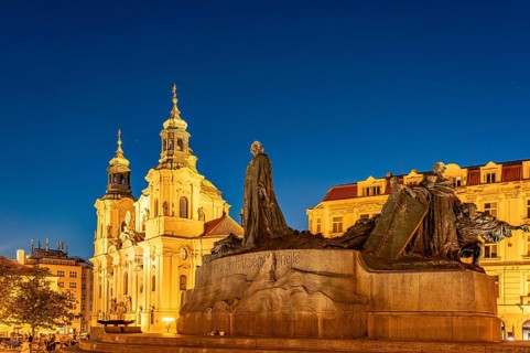 The Baroque St. Nicholas Church and the Jan Hus Memorial on Old Town Square at dusk, Prague, Czech
