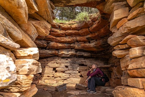 Tourist sitting in the Palli-Lakka Drakospita dragon house near Styra, island of Euboea or Evia,