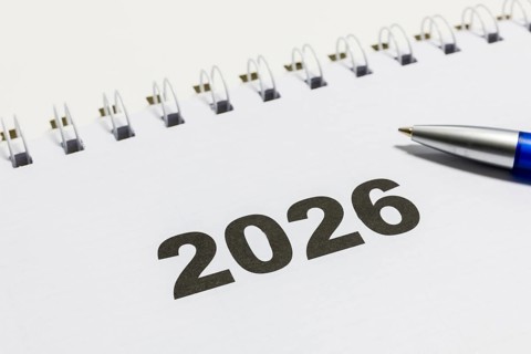 Ring book calendar for the year 2026 with ballpoint pen on white background