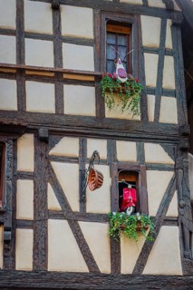 Timber-frame house decorated with vehicles in the historic old town of Riquewihr, Ellsass