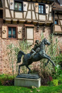 Statue of a woman riding with horse La Dame du Parc in Riquewihr