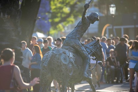 Metal sculpture of a polo player on the grounds of the polo stadium with many visitors, Buenos