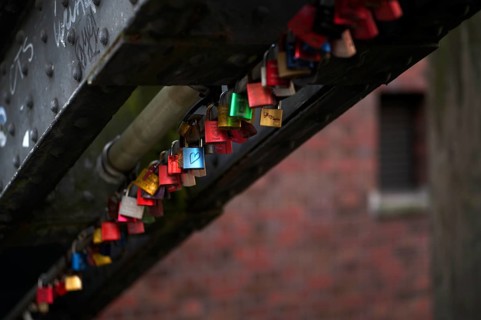 Colourful, colorful love locks hang on a bridge, warehouses, brick buildings, Hamburger