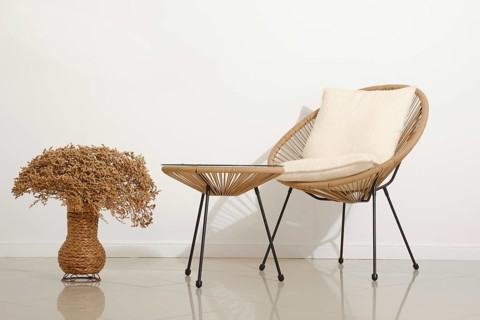 A cozy chair with soft cushioning sits next to a small, stylish table in a contemporary living area