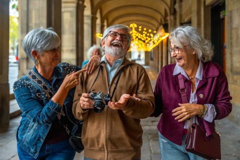 Group of excited senior friends enjoying their city trip, laughing and walking together in an
