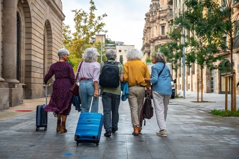 Group of diverse senior women friends enjoying city travel together, walking on an urban street