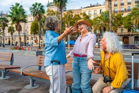 Diverse group of happy senior friends enjoying their city holiday together, laughing and