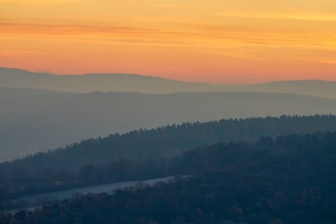 Gentle hills in fog at a warm sunset create a peaceful natural landscape, Seckmauern, Lützelbach,
