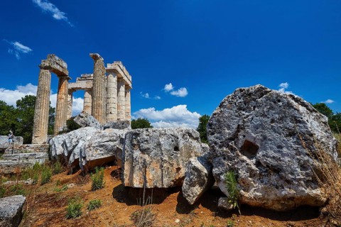 Large stones and ancient pillar remains under bright blue sky, Nemea, Ancient Zeus Heightum,