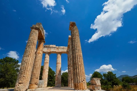 Pillars of an ancient structure under a clear sky with few clouds, Nemea, Ancient Zeus Heightum,