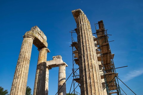 Old pillars with scaffolding, clear sky. Greek Ruins, Nemea, Ancient Zeus Heightum, Archaeological
