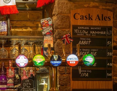 Cask ale menu of different brands inside the Ship pub, Exeter, Devon, England, UK - keg beer taps