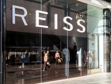 Shoppers walking reflected in Reiss shop store window in city centre, Princesshay, Exeter, Devon,