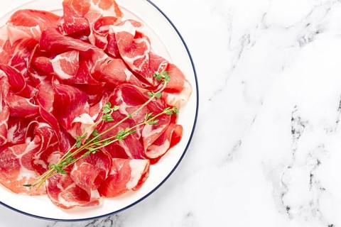 Plate with sliced cured meat, pork neck, prosciutto coppa, Italian delicacy