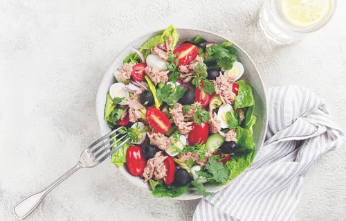 Salad with canned tuna, vegetable salad with quail eggs, lettuce and romaine leaves, red onion,