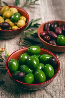 A mixture of olives, varieties of chalkidiki, Verdi giganti and Kalamata, in a bowl, top view, no