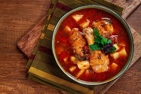 Souzi soup. Georgian dish, meat with oats, tomato sauce and herbs, on a wooden table