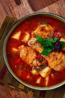 Souzi soup. Georgian dish, meat with oats, tomato sauce and herbs, on a wooden table