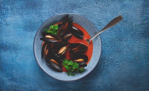 Fra Diavolo mussels, mussels in tomato sauce, Italian dish, on a blue background, homemade, no