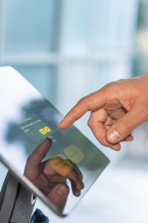 Close-up of a hand touching a touchscreen with reflective display, robotic personality Roboloutions