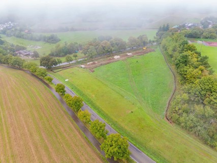 Aerial view of a foggy rural landscape with fields and roads, construction of a PV open-air system,