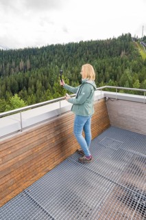 Person with selfie stick enjoying views of wooded hills from a vantage point, Ruhestein National