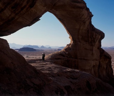 Bedouin under a natural rock bridge, Wadi Rum, Jordan