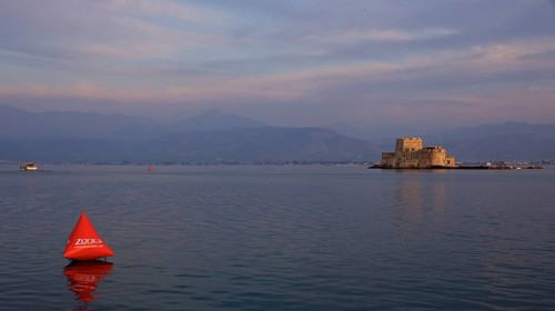 Bourtzi Island Fortress, A fortress in the sea at dusk with an orange buoy in calm water, Nauplion,