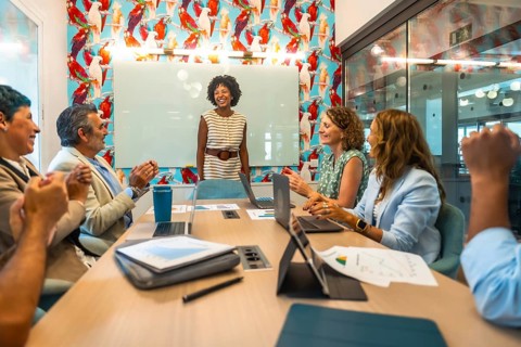 Diverse business colleagues showing appreciation for a successful presentation in a modern