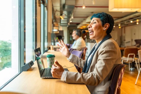 Business professional with headset actively communicating during an online video conference from a