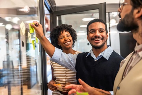 Diverse business professionals collaborating in a modern office, cheerfully sharing innovative