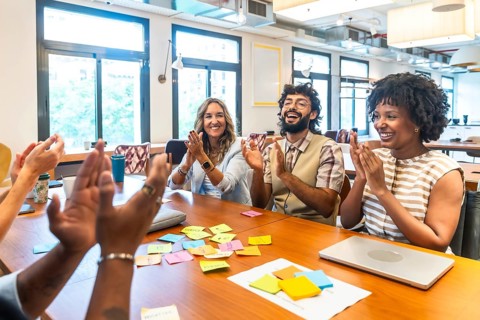 Diverse business colleagues at a modern coworking space collaborating and expressing happiness and