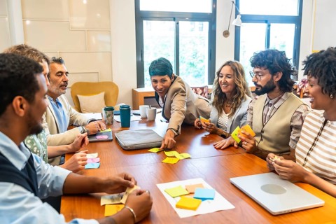 Diverse business team collaborating energetically around a table, exchanging ideas, brainstorming