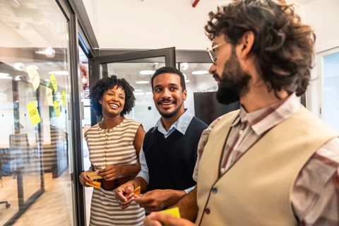 Diverse business professionals collaborating happily, exchanging creative ideas, and planning