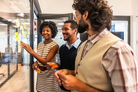 Diverse business team collaborating in a modern office, sharing ideas and planning strategy by